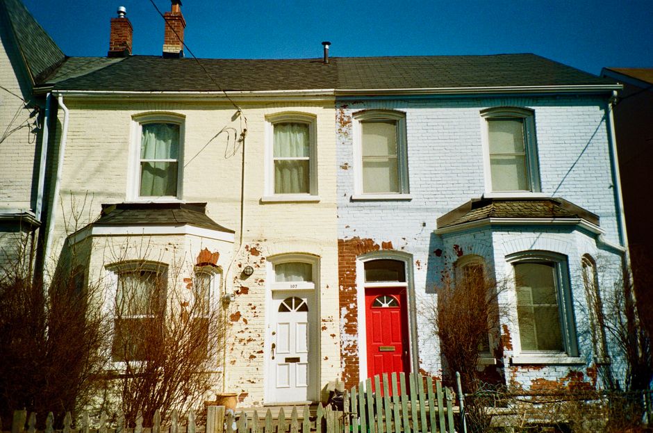 Painted houses with red and white doors in a row.